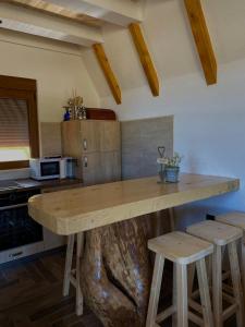 a kitchen with a large wooden table and stools at Srce Zminice in Žabljak