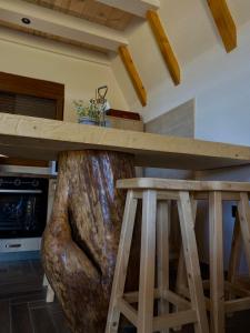 a large tree stump table in a kitchen with a counter top at Srce Zminice in Žabljak +16 photos