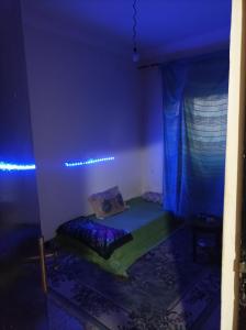 une chambre avec un lit dans une chambre avec des lumières bleues dans l'établissement Ain sbaa Hay mohmmadi, à Casablanca