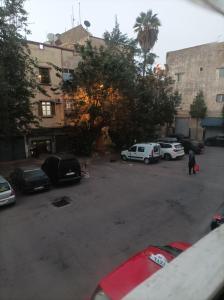parking z samochodami zaparkowanymi przed budynkiem w obiekcie Ain sbaa Hay mohmmadi w mieście Casablanca