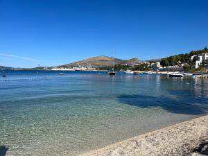 a beach with a body of water with boats in it at Apartments Villa Mirella 20 m from the sea - free parking in Trogir