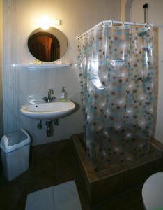 y baño con ducha y lavamanos. en Pestújhely Panzió-étterem, en Budapest