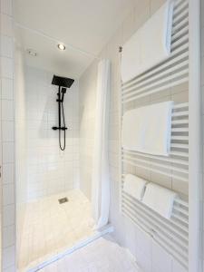 a bathroom with a shower with white tiles at Canal View Stay Amsterdam in Amsterdam