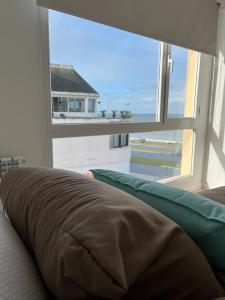 a bed in a room with a large window at Excelente! 4 personas frente al mar con cochera in Mar del Plata