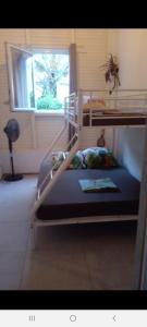 two bunk beds in a room with a window at Chambre chez l'habitant avec piscine privative et vue panoramique sur la mer des caraïbes in Desmarinières