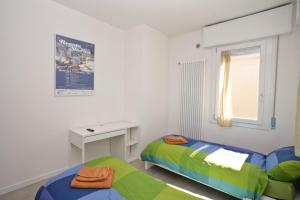 1 dormitorio con 2 camas, escritorio y ventana en Venice Residence Elisabeth en Mestre