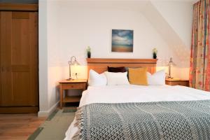 a bedroom with a large white bed with pillows at Oewern Diek App 55 in Wustrow