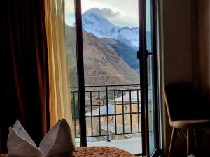 a room with a window with a view of a mountain at Hotel Sweet Night in Stepantsminda