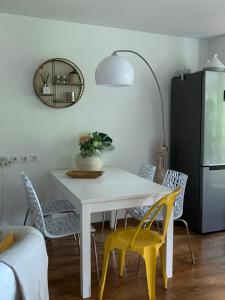 uma sala de jantar com uma mesa branca e cadeiras amarelas em Entre Neige et Thermes em Brides-les-Bains