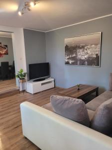a living room with a white couch and a television at Apartament MariaNova 100m2 Zabrze Pawłów in Zabrze