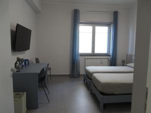 1 dormitorio con cama, escritorio y ventana en Marea, en Messina