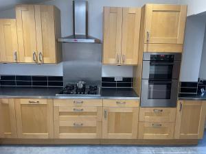 a kitchen with wooden cabinets and a stove top oven at Home away from Home in Cross Gates