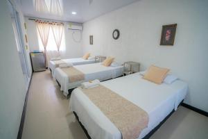 a group of four beds in a room at Posada Jasmina Place in Providencia