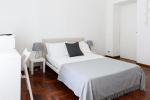 a bedroom with a white bed with a black pillow at B&D Dolce Vita in Rome