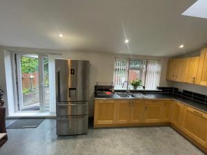 a kitchen with a stainless steel refrigerator and wooden cabinets at Home away from Home in Cross Gates