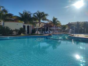 een groot zwembad in een resort met palmbomen bij Casa Praia de Taperapuan em Porto in Porto Seguro