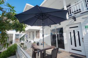 una mesa de madera con una sombrilla en el patio en Posada Jasmina Place, en Providencia