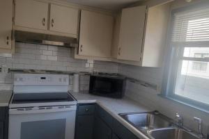 a kitchen with a stove and a sink and a microwave at Quiet 3 bed with fenced yard in Columbus