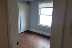 um quarto vazio com uma janela e um piso de madeira em Quiet 3 bed with fenced yard em Columbus