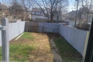 a white fence in a yard next to a house at Quiet 3 bed with fenced yard in Columbus