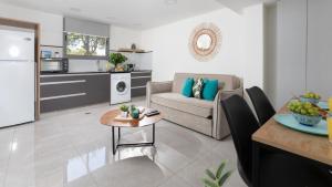 una cucina e un soggiorno con divano e tavolo di By Eezy - אורה דירות אירוח a Eilat