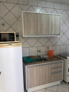 uma cozinha com um micro-ondas e uma bancada em Residêncial Beatríz em Florianópolis