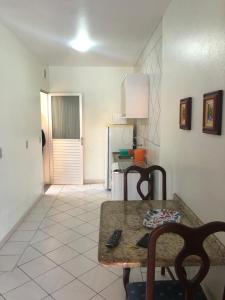 um quarto com uma mesa e uma cozinha com um frigorífico em Residêncial Beatríz em Florianópolis
