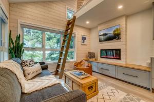 a living room with a loft bed and a tv at creekside Innsbrook in Whistler