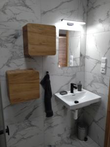 a bathroom with a white sink and a mirror at Apartmán Karlovice - Jeseníky in Karlovice