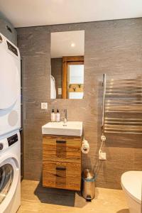a bathroom with a sink and a washing machine at Sonnhalde II - Luxury Chalet in Saas-Fee