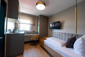 a bedroom with a bed and a desk and a sink at V Business Apartments Böblingen in Böblingen