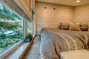 een slaapkamer met een bed en een groot raam bij creekside Innsbrook in Whistler