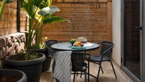 un tavolo e sedie su un patio con piante di By Eezy - אורה דירות אירוח a Eilat