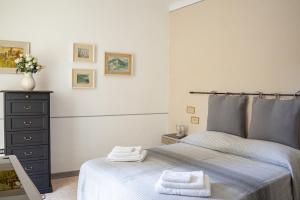 a bedroom with a bed and a dresser with towels on it at Casa vacanze nel centro storico di Fermo Happy Song in Fermo