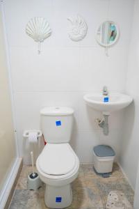 a white bathroom with a toilet and a sink at Posada Jasmina Place in Providencia