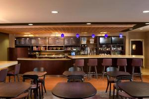 a bar with tables and chairs in a restaurant at Courtyard by Marriott Jackson in Jackson