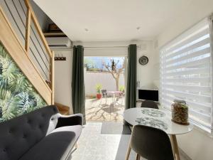 a living room with a table and chairs and a window at Petite Maison indépendante. in Béziers