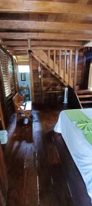 um quarto com uma cama e uma cadeira num quarto em Hotel Ecologico Makalombia em La Macarena