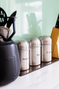 Un estante con varios botes de metal encima. en Cozy and Small Studio Zone 2 near Maida vale 6, en Londres