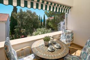 a balcony with a table and chairs and a window at Apartmani Biserka in Mandre