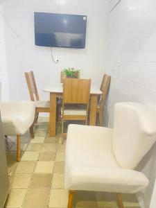 uma sala de jantar com mesa e cadeiras e uma televisão em Apartamento em Boa Viagem no Recife