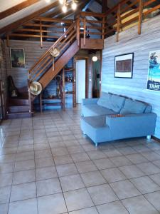 ein Wohnzimmer mit einem blauen Sofa und einer Treppe in der Unterkunft Enzo lodge chambre hibiscus in Papawa