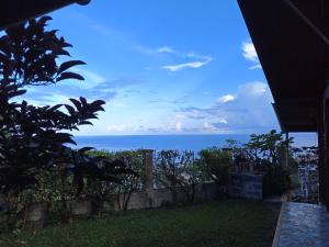 uma vista para o oceano a partir de uma casa em Enzo lodge chambre hibiscus em Papawa