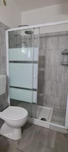 a bathroom with a toilet and a glass shower at La Casa del mare in Rosolina Mare