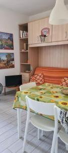 een eetkamer met een tafel en een bank bij La Casa del mare in Rosolina Mare