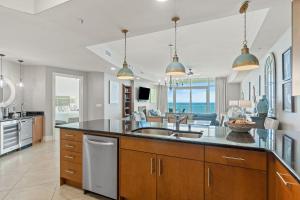 a kitchen with a sink and a living room at Turquoise C1706 in Orange Beach