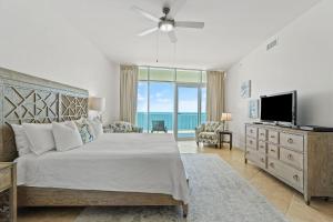 a bedroom with a bed and a television with a view of the ocean at Turquoise C1706 in Orange Beach