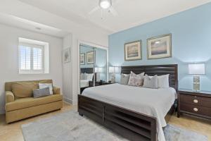 a bedroom with a large bed and a chair at Turquoise C1706 in Orange Beach +49 photos