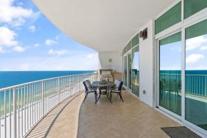 a balcony with a table and chairs and the ocean at Turquoise C1706 in Orange Beach