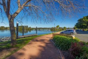 een auto geparkeerd naast een waterlichaam bij Home Plus TAREE CBD in Taree